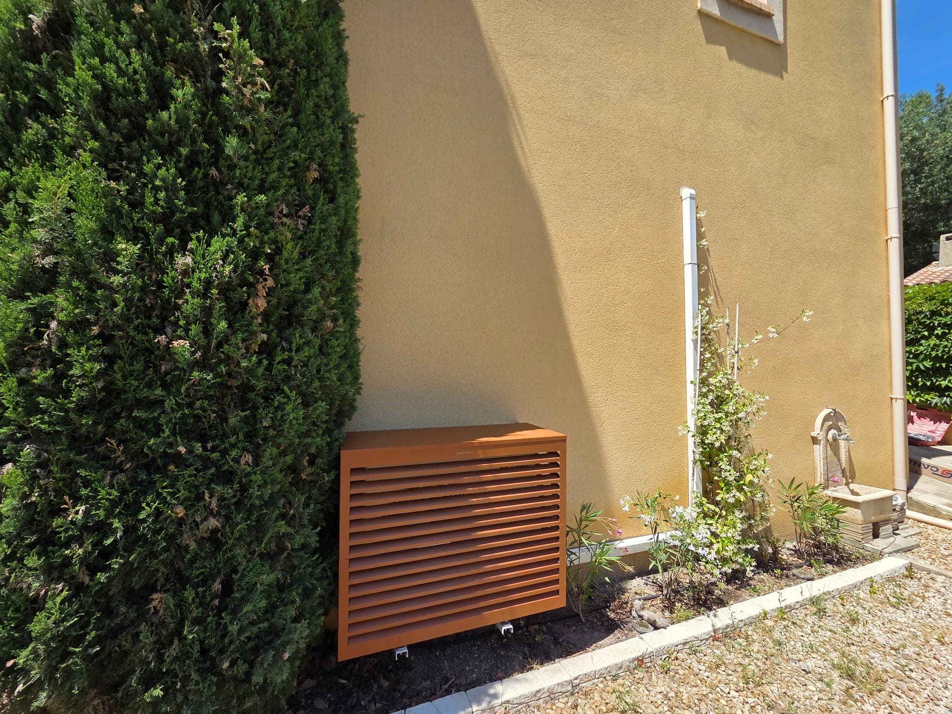 Même groupe extérieur masqué par un cache aluminium à lattes ventilées, après habillage sur mesure