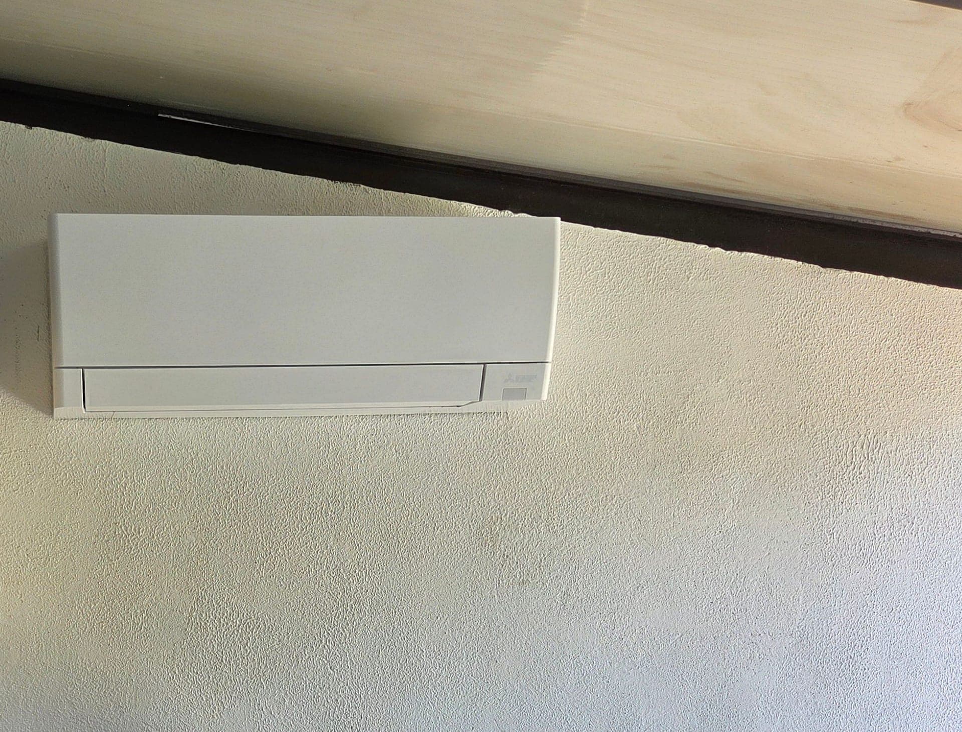 Split mural de climatisation Mitsubishi Electric sur mur clair — pose à Grans