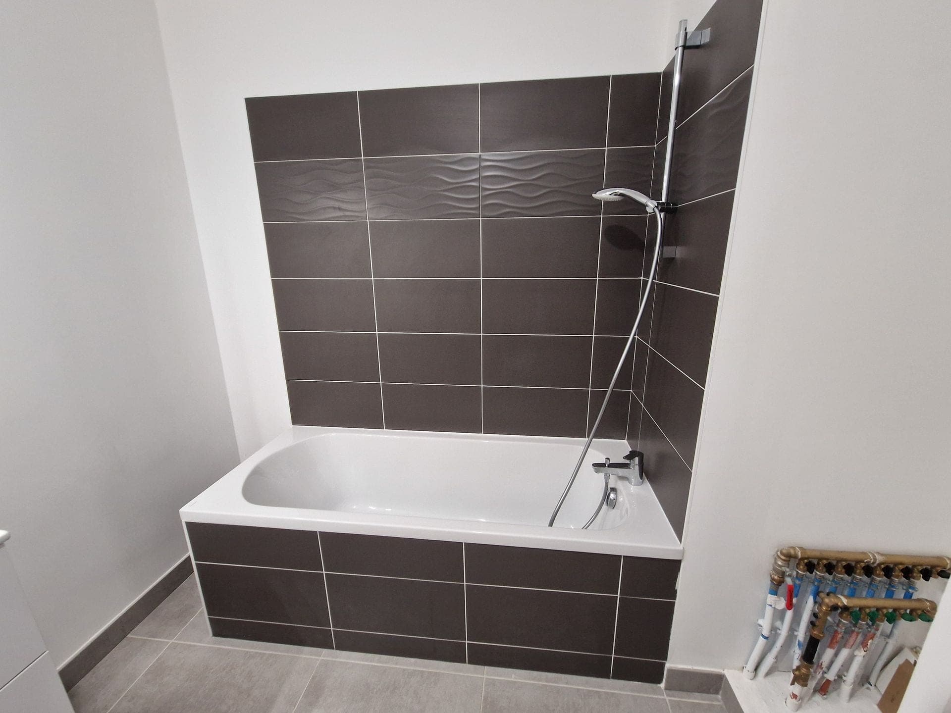 Baignoire encastrée et douche carrelage noir — chantier plombier Pélissanne
