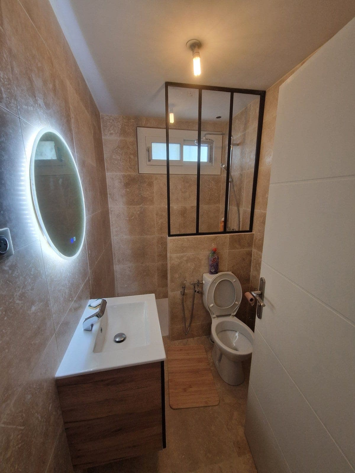 Salle de bain travertin avec verrière acier noir