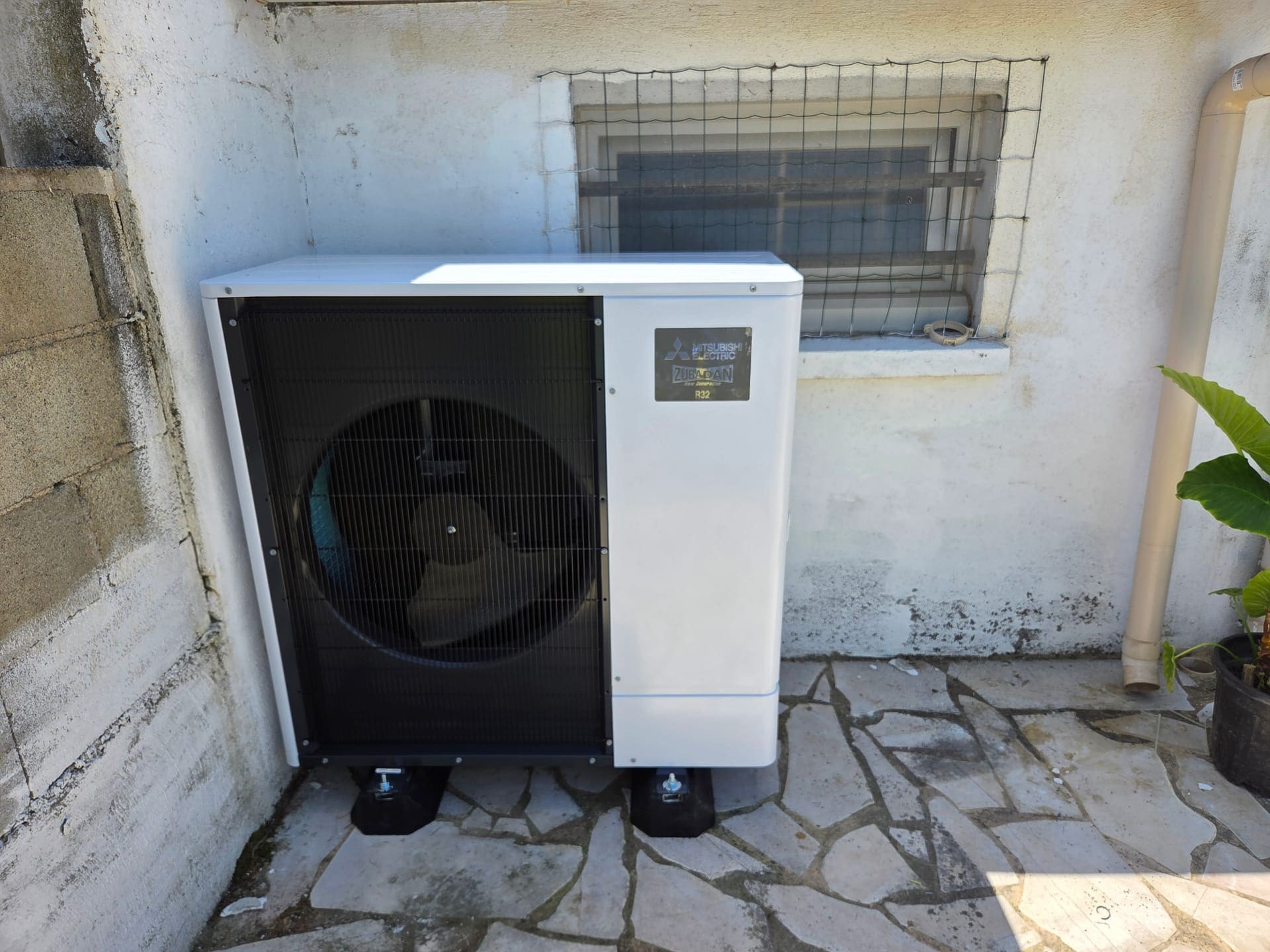 Groupe extérieur de climatisation Mitsubishi Electric sur plots anti-vibration en terrasse — chantier secteur Salon-de-Provence